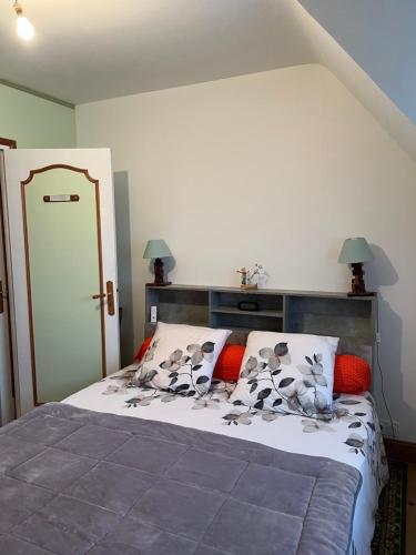 a bedroom with a large bed with red pillows at Les coccinelles bretonnes in Plouescat