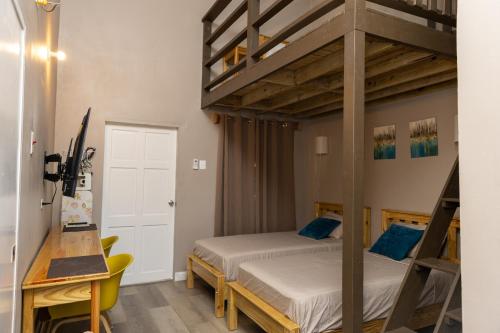ein Schlafzimmer mit zwei Etagenbetten und einem Schreibtisch in der Unterkunft Comfi Spaces in Canaan
