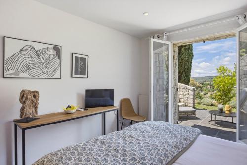 a bedroom with a bed and a desk and a window at A Casa Bianca in Saint Paul de Vence