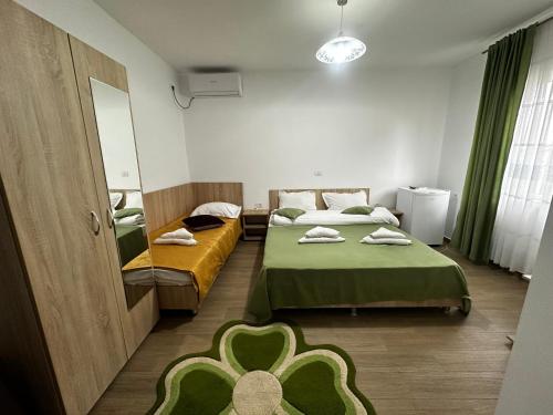 a small room with two beds and a mirror at Casa Enka in Tuzla