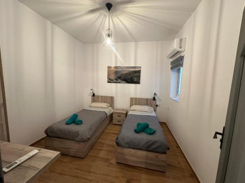 two beds in a small room with a ceiling at 119 Bliss Apartment in Sliema
