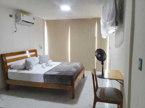 a bedroom with a bed and a desk and a chair at Hotel Riviera del Atrato in Bojayá