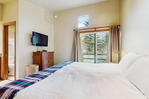 a bedroom with a large white bed and a window at Mountain Magic in Ketchum