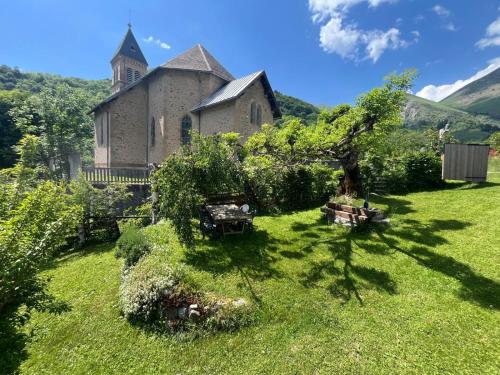 an old building with a church in the grass at Chalet Vue Montagne 6 personnes proche Sanctuaire de La Salette in La Salette-Fallavaux