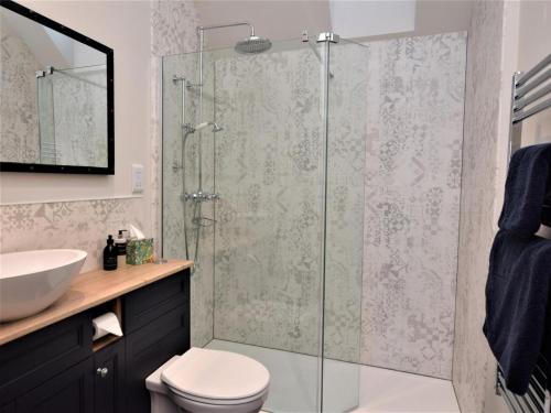 a bathroom with a shower with a toilet and a sink at 1 Bed in Alness oc-83888 in Alness