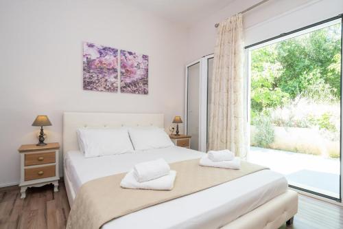 a bedroom with a bed and a large window at Orchid Garden Apartment in Sami