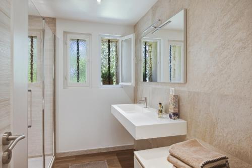 a white bathroom with a sink and a shower at A Casa Bianca in Saint Paul de Vence