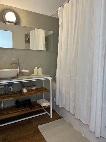 a bathroom with a sink and a shower curtain at Orphé37, grand appartement cocon au cœur de la Gascogne artistique in Lectoure