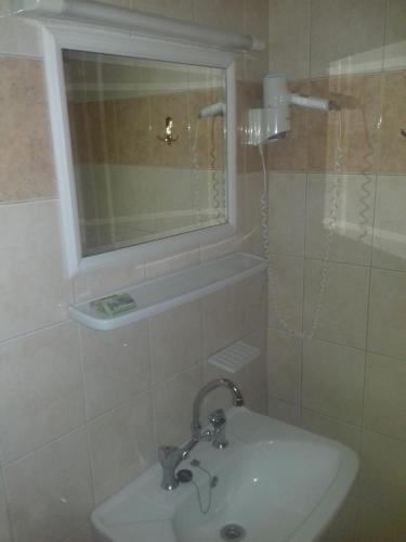 a bathroom with a sink and a window and a mirror at Pension Castello in Rethymno