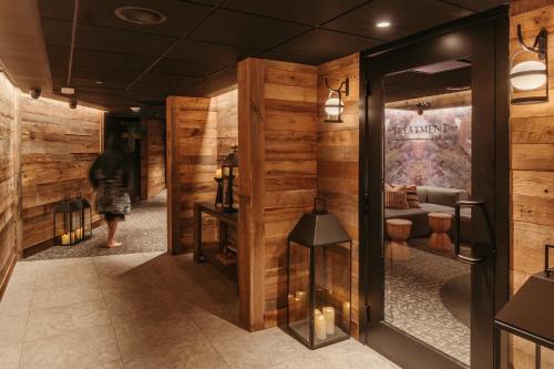 a woman walking through a lobby with wooden walls at Everwild Canmore Hotel in Canmore