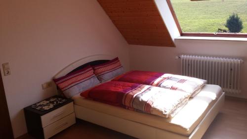 a small bedroom with a bed with a window at Ferienwohnung Ringwald in Biederbach Baden-Württemberg