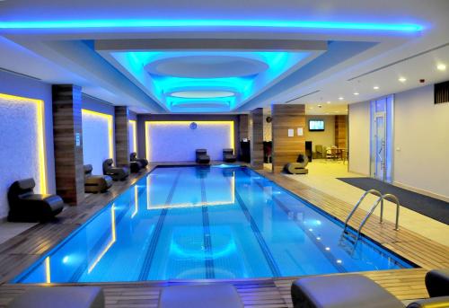 una gran piscina en un hotel con luces azules en Ozpark Hotel, en Aksehir