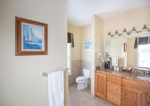 a bathroom with a sink toilet and a picture of a sailboat at Smithfield Station in Smithfield