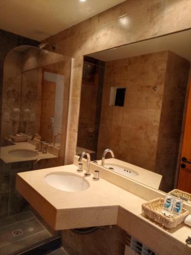 a bathroom with a sink and a large mirror at KALLPA WARMI Hotel Panoramico in Tilcara