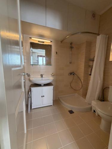 a bathroom with a sink and a shower and a toilet at Cozy Aegean Escape in Skopelos Town