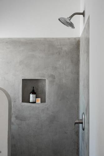 een badkamer met een douche en een fles op een plankje bij Casa Beu Hotel Boutique in Puerto Escondido