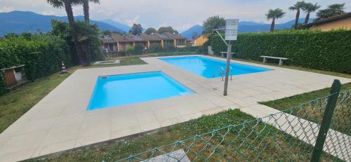 a large blue swimming pool in a yard at The Hidden Gem, Lago Maggiore in Germignaga