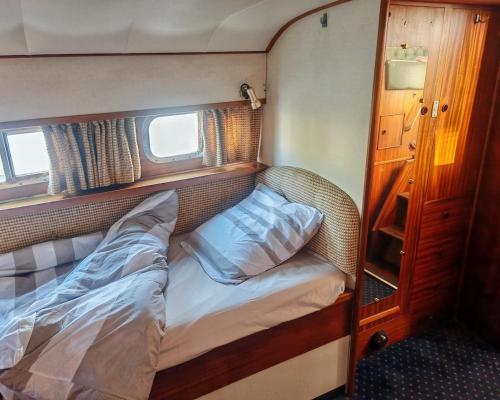 a small bed in a small room on a boat at bateau nuit insolite in Carentan