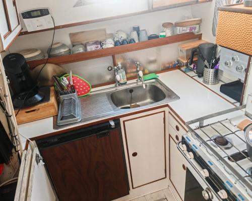a small kitchen with a sink and a counter at bateau nuit insolite in Carentan