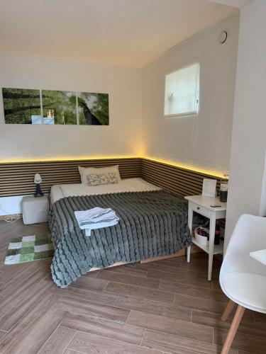 a small bedroom with a bed and a desk at Studio Ohlendorf 3 Min zur A7 mit Parkplatz in Seevetal