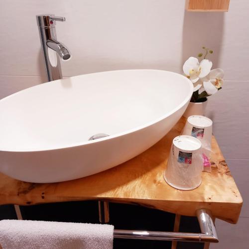 a bathroom with a white sink on a wooden table at HOTEL RURAL ORQUIDEA in Velilla del Río Carrión