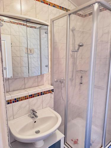 a bathroom with a sink and a shower at La petite Lotie in Saint-Denis-dʼOléron