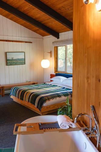 a bedroom with a bed and a tub and a sink at Captain Whidbey in Coupeville