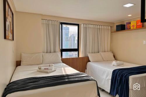 a hotel room with two beds and a window at Edifício MOVE Novo- Tambaú in João Pessoa