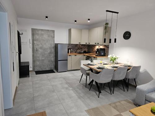 a kitchen and dining room with a table and chairs at Blue Wave Pobierowo in Pobierowo