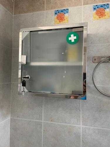 a mirror in a bathroom with a plus sign on the wall at Apartment for Family 2 in Kallithea Halkidikis