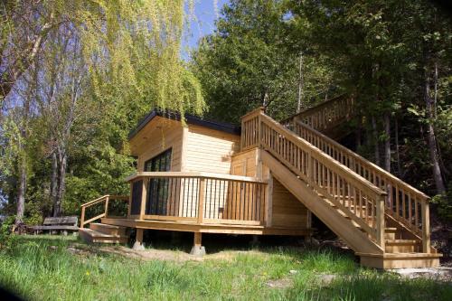 a large wooden cabin with a staircase in the woods at Tanglewood - Large Waterfront Home in PEC ST-2020-0172 in Waupoos