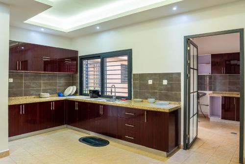 a kitchen with wooden cabinets and a sink and a window at Mandela Suite, Ngor Almadies, Dakar, Senegal Appart 2 chambres, 2 salles de bain in Dakar