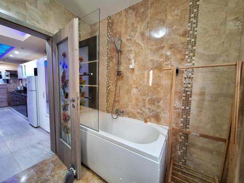 a bathroom with a tub and a glass shower at Chic Peak Apartment - Kalinderu Slope & View in Buşteni