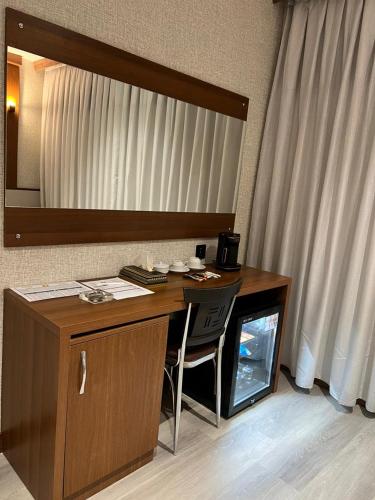 a desk with a mirror and a chair in a room at زاده هوتيل - Zade Hotel in Duhok