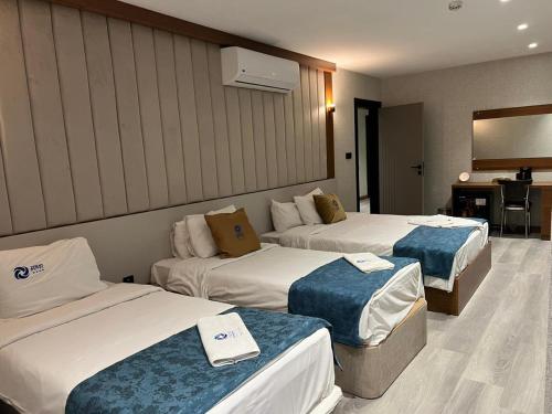 a hotel room with three beds in a room at زاده هوتيل - Zade Hotel in Duhok