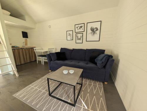 a living room with a blue couch and a table at Kuggeboda in Listerby