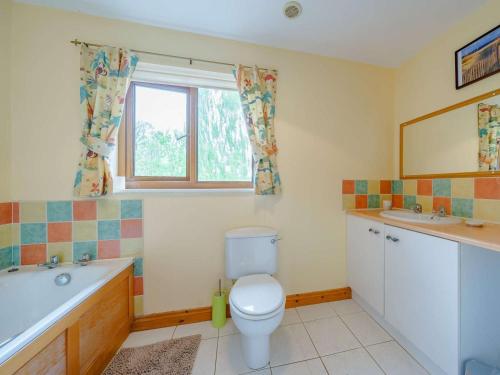 a bathroom with a toilet and a tub and a sink at 3 Bed in Brecon oc-83076 in Aber-Brân