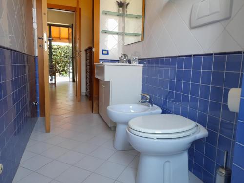 a blue tiled bathroom with a toilet and a sink at CasaEma in Torre del Lago Puccini