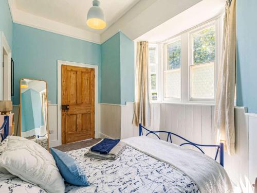 a bedroom with blue walls and a bed and a mirror at 1 Bed in Chulmleigh oc-88862 in Chawleigh