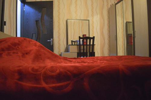 a bed with a red blanket on top of it at Apartament 2 in Gonio