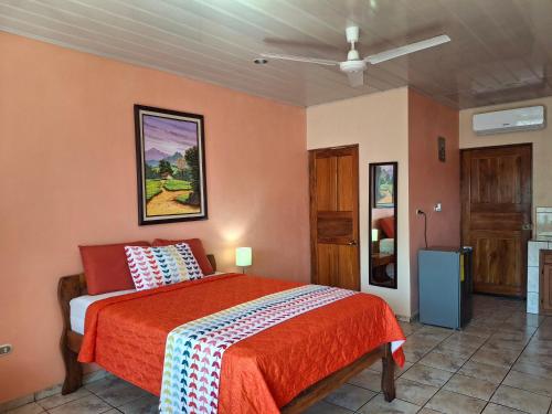 a bedroom with a bed with a red blanket at Quepos Studio Apartments in Quepos