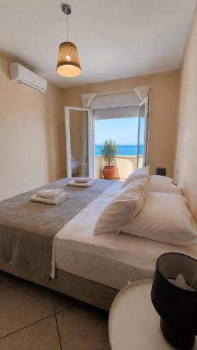 a bedroom with a large bed with a view of the ocean at Venetiko rooms in Chios