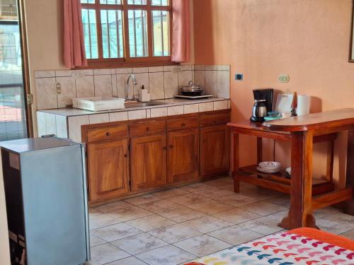 a kitchen with a refrigerator and a table in it at Quepos Studio Apartments in Quepos