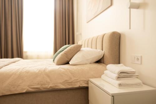 a bedroom with a bed and a table with towels at Central Apartment Chortkiv in Chortkiv