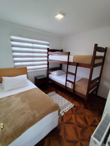 a bedroom with two beds and a desk and a laptop at Cabañas Terravento in Puerto Natales