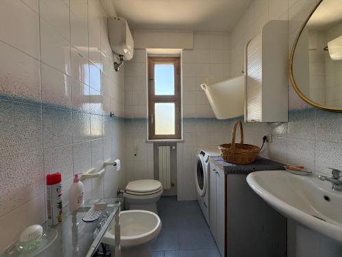 a bathroom with a toilet and a sink and a mirror at Happy's Casa in Putignano