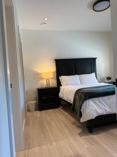 a bedroom with a bed and a night stand with a lamp at Luxury EW Bed & Breakfast in Abbotsford