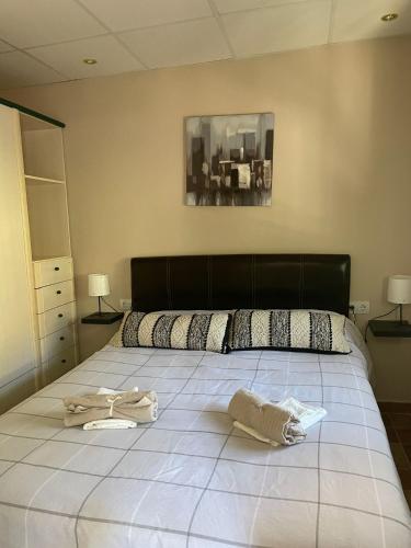a bedroom with a large bed with two towels on it at La casa del rio cauche in Almogía