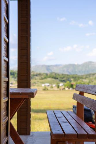 a wooden bench sitting on a porch with a view at Mountain Home Zaborje in Plužine