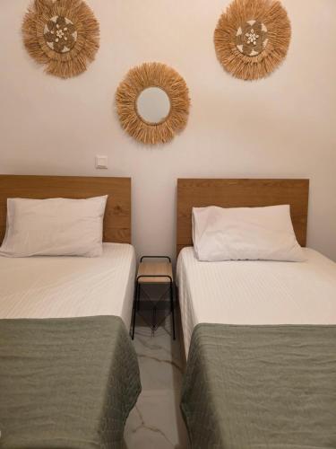 two beds in a room with two mirrors on the wall at Le Blé Home in Mérikhas